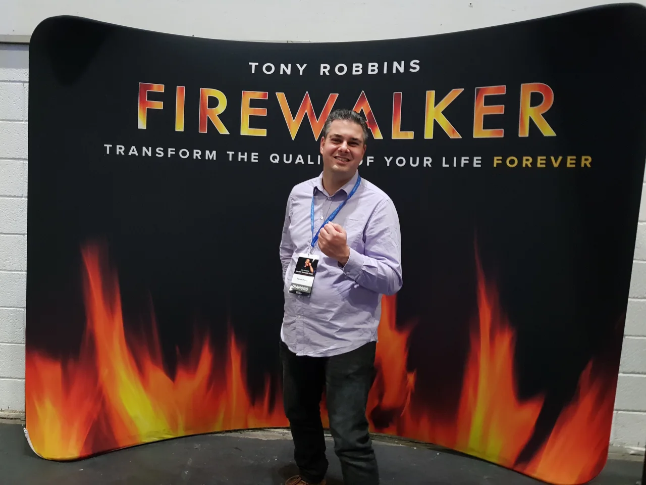 Manuel Möbius 2017 vor dem Firewalker-Motiv eines Tony-Robbins-Seminars in London.